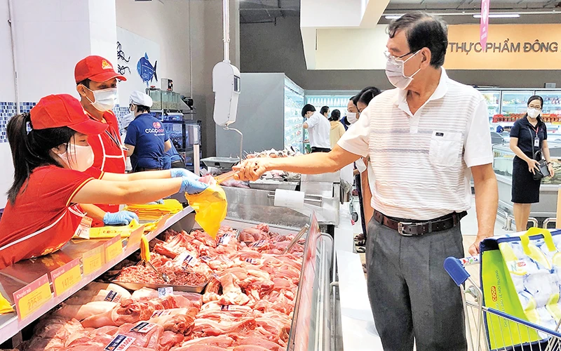 Người tiêu dùng mua thịt heo ở một siêu thị Co.opmart.Ảnh: CTV