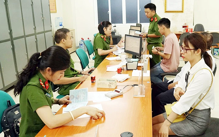 Các cán bộ chiến sĩ công an hỗ trợ người dân làm thủ tục đổi thẻ căn cước công dân tại Phòng Cảnh sát quản lý hành chính về trật tự xã hội (Hà Nội). Ảnh: PHƯƠNG MINH