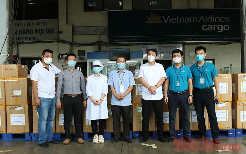 Đại diện Công ty Medicon, đại diện Báo Nhân Dân và Hãng hàng không Vietnam Airlines chuyển bộ kit xét nghiệm vào TP Hồ Chí Minh. 
