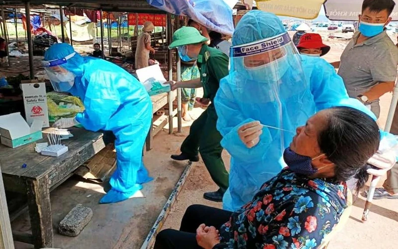Lực lượng chức năng lấy mẫu giám sát dịch tễ trong cộng đồng ở xã Nghi Sơn.
