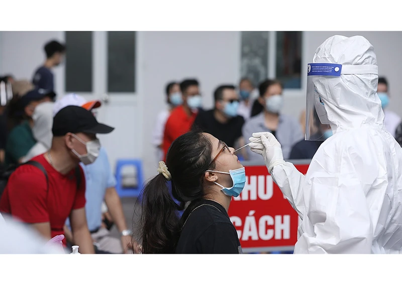 Nhân viên y tế quận Hai Bà Trưng (TP Hà Nội) lấy mẫu xét nghiệm Covid-19 cho các trường hợp trở về từ TP Hồ Chí Minh ngày 10/7. Ảnh TTXVN