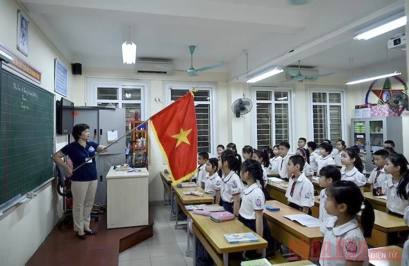 Lễ chào cờ đầu tuần diễn ra trong lớp học thay vì tập trung ở sân trường, của học sinh tiểu học. Ảnh: DUY LINH