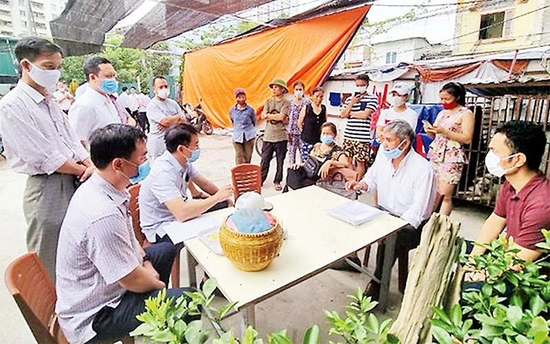 Lực lượng chức năng quận Hoàng Mai và phường Thịnh Liệt tuyên truyền, vận động, thuyết phục các hộ dân bàn giao mặt bằng cho dự án tuyến đường Vành đai 2,5. Ảnh: VŨ LÊ