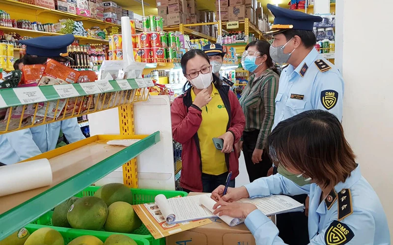 Cán bộ Quản lý thị trường tỉnh Sóc Trăng lập biên bản xử lý cửa hàng bách hóa về hành vi bán hàng cao hơn giá niêm yết.