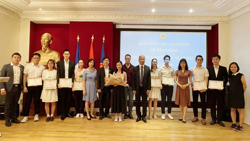 Đại sứ Đinh Toàn Thắng (thứ 7 từ phải sang) và Ban tổ chức chụp ảnh lưu niệm cùng các sinh viên đoạt giải.