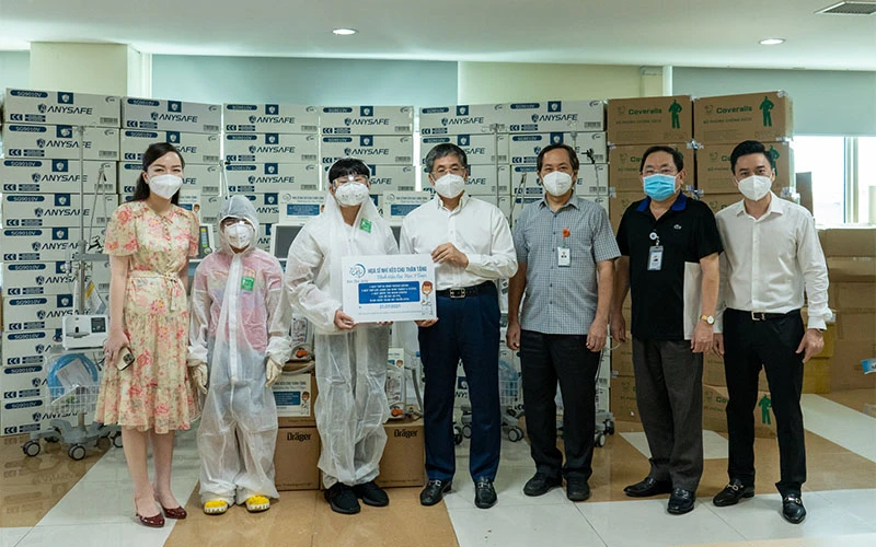 Hoạ sĩ Xèo Chu trao thiết bị y tế cho đại diện Bệnh viện Đại học Y dược TP Hồ Chí Minh chiều 21/7 (nguồn: Bệnh viện Đại học Y dược TP Hồ Chí Minh)