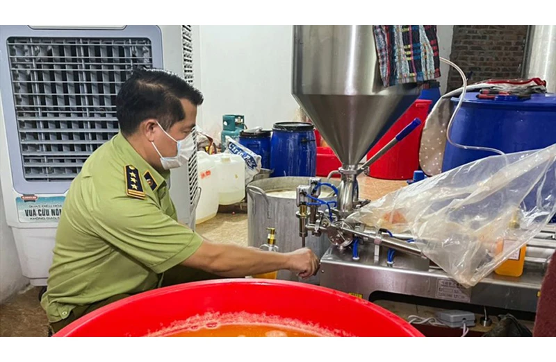 Lực lượng Quản lý thị trường Hà Nội kiểm tra cách thức sản xuất mỹ phẩm giả tại cơ sở thuộc xã Hồng Dương, huyện Thanh Oai (Hà Nội). Ảnh: BẢO AN