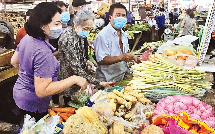 Người dân mua rau, củ, quả tại chợ An Đông (quận 5) trong buổi sáng ngày 20/7.