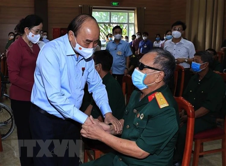 Chủ tịch nước Nguyễn Xuân Phúc đến thăm hỏi, tặng quà các thương bệnh binh tại Trung tâm Nuôi dưỡng thương bệnh binh nặng và điều dưỡng người có công tỉnh Hà Nam. (Ảnh: TTXVN)