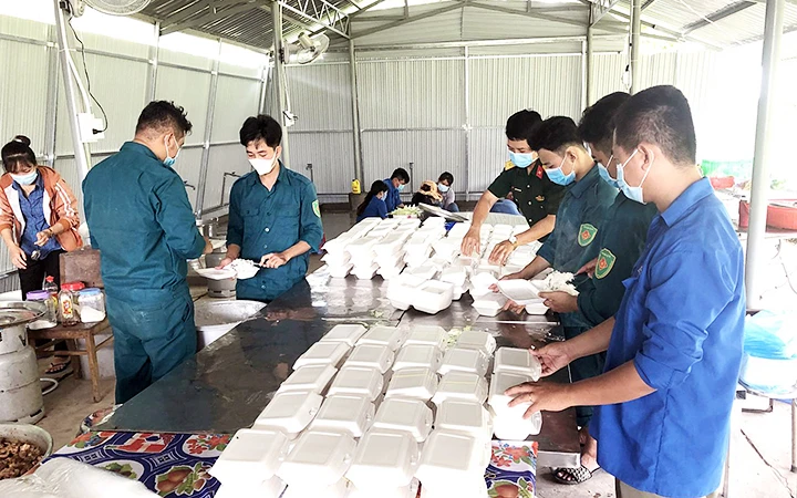 Các anh nuôi của bếp ăn Ban Chỉ huy quân sự huyện Châu Thành (Long An) chuẩn bị bữa ăn phục vụ người dân trong khu cách ly. Ảnh: VÂN ANH