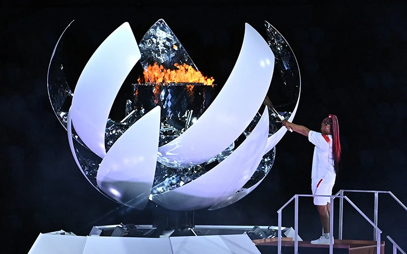 Vận động viên quần vợt Naomi Osaka của Nhật Bản thắp sáng ngọn đuốc Olympic tại lễ khai mạc. Ảnh AFP/TTXVN