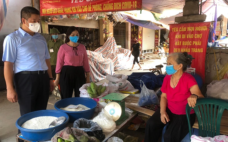 Phó Chủ tịch UBND TP Hà Nội Nguyễn Mạnh Quyền nhắc tiểu thương tại Chợ trung tâm thị trấn Chúc Sơn tuân thủ các yêu cầu phòng chống dịch Covid-19.