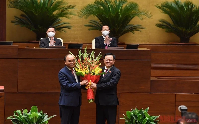 Chủ tịch Quốc hội Vương Đình Huệ tặng hoa chúc mừng Chủ tịch nước Nguyễn Xuân Phúc. (Ảnh: DUY LINH)
