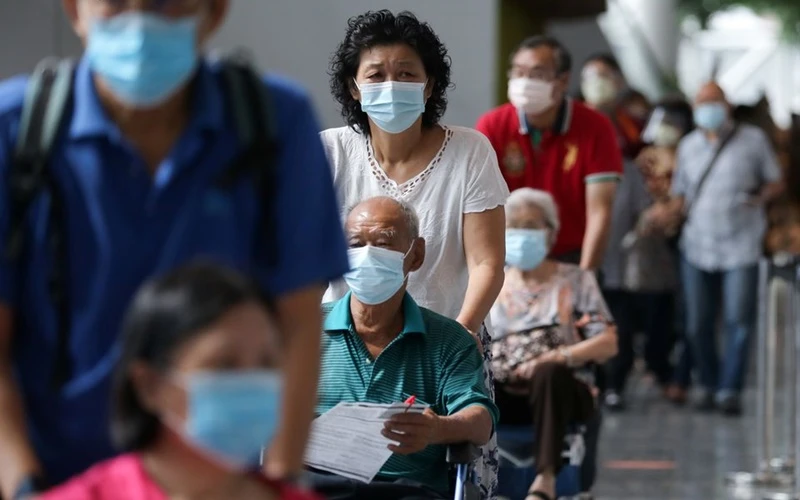 Người dân chờ tiêm vaccine ngừa Covid-19 tại trung tâm tiêm chủng ở Kuala Lumpur, Malaysia. (Ảnh: Reuters)