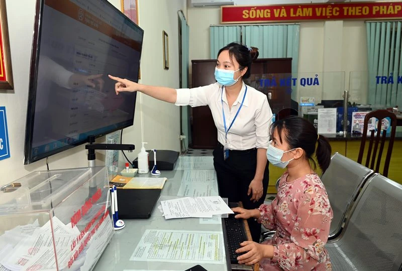 Hướng dẫn người dân thực hiện dịch vụ công trực tuyến tại phường Trung Hòa, quận Cầu Giấy, Hà Nội (ảnh chụp trước ngày TP Hà Nội thực hiện giãn cách xã hội). (Ảnh: DUY LINH)