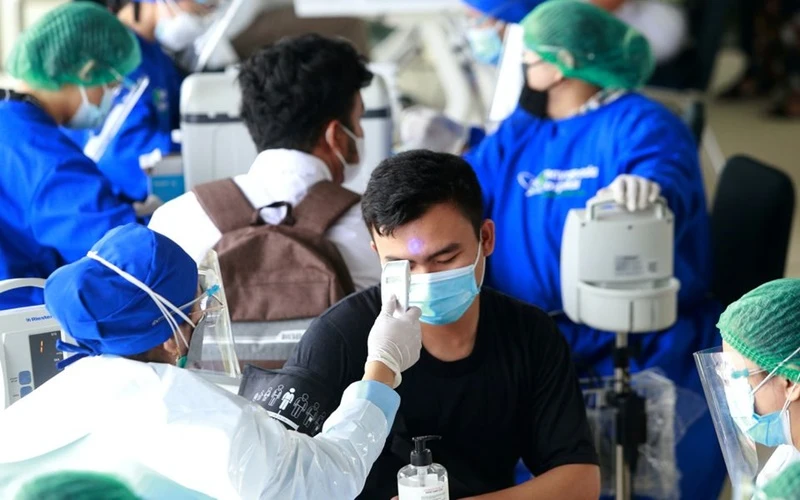 Kiểm tra thân nhiệt trước khi tiêm vaccine ngừa Covid-19 tại Jakarta, Indonesia. (Ảnh: Reuters)