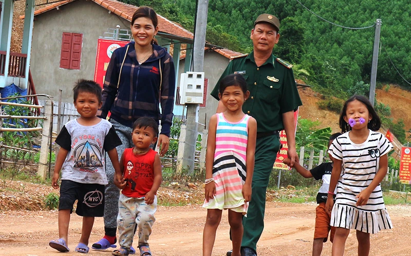 Bí thư Chi bộ kiêm Trưởng bản Hồ Thị Kiên cùng chiến sĩ Đồn Biên phòng Bản Giàng tích cực vận động bà con dân tộc Chứt cho con em mình đến trường.