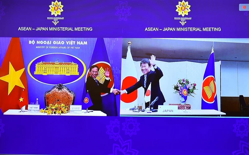 Bộ trưởng Ngoại giao Việt Nam và Nhật Bản bắt tay qua màn hình để chuyển giao vai trò điều phối quan hệ ASEAN - Nhật Bản. (Ảnh do báo Thế giới và Việt Nam cung cấp)