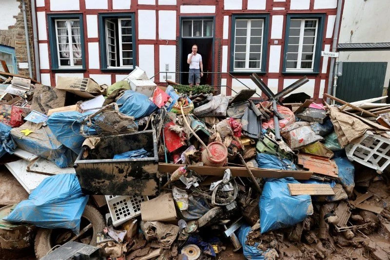 Một người đàn ông nhìn ra ngoài ngôi nhà trong khu vực bị ảnh hưởng bởi lũ lụt do mưa lớn ở Bad Muenstereifel, Đức, ngày 19/7. (Ảnh: Reuters).