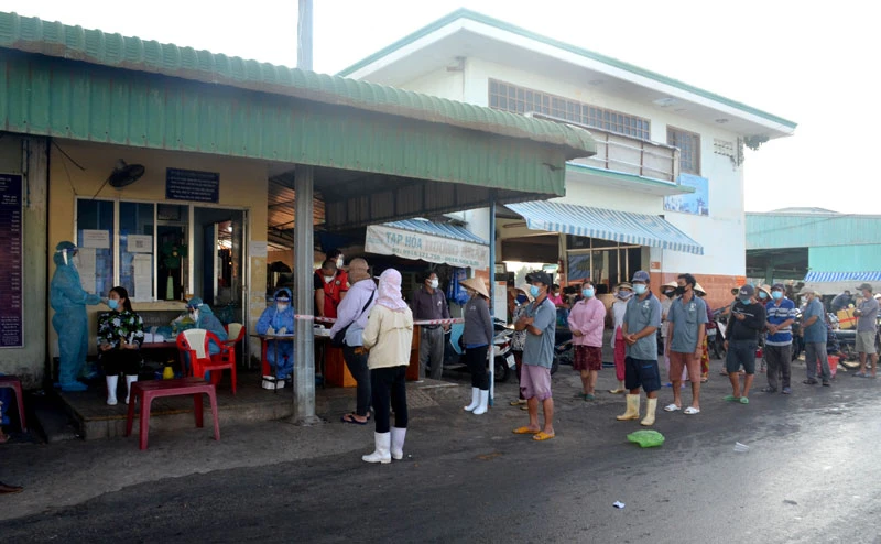 Người lao động tại khu vực Chợ cá Cồn Chà thuộc Cảng cá Phan Thiết (Bình Thuận) chờ lấy mẫu test nhanh SARS-CoV-2. 