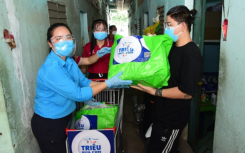 Tình nguyện viên trao nhu yếu phẩm của chương trình “Triệu bữa cơm” tặng ngươi dân có hoàn cảnh khó khăn tại TP Hồ Chí Minh.