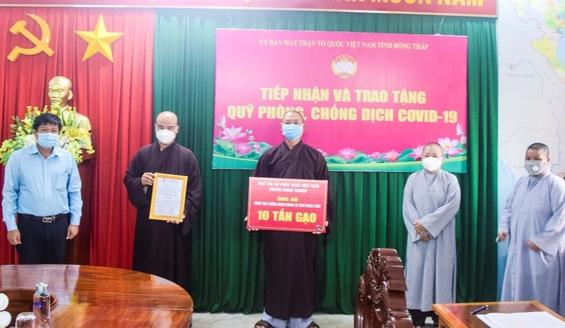 Đại diện Ban Trị sự Phật giáo Việt Nam huyện Châu Thành trao tặng bảng tượng trưng 10 tấn gạo.