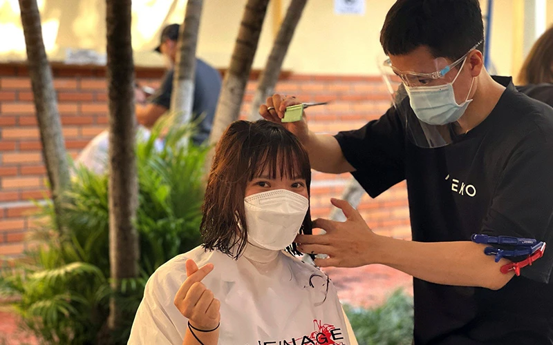 Nhóm thiện nguyện cắt tóc miễn phí cho các y, bác sĩ Bệnh viện Hữu nghị Việt Ðức trước ngày lên đường vào Trung tâm Hồi sức tích cực Covid-19 ở TP Hồ Chí Minh. Ảnh: CTV