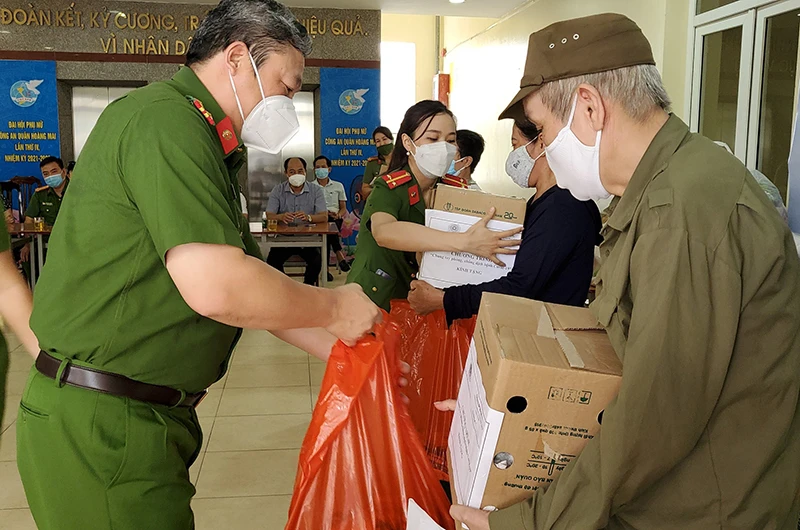Đại tá Nguyễn Đình Chiến, Trưởng Công an quận Hoàng Mai trao tặng suất quà cho đại diện các hộ gia đình có hoàn cảnh khó khăn trên địa bàn.