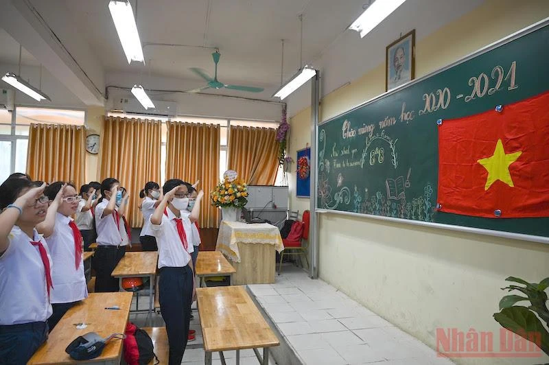 Các em học sinh thực hiện nghi lễ chào cờ khai giảng năm học mới tại lớp học năm học 2020-2021. Ảnh: DUY LINH
