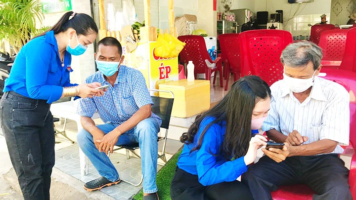 Đoàn viên, thanh niên huyện Long Phú tích cực tuyên truyền, hướng dẫn người dân cài đặt các ứng dụng Bluezone, tokhaiyte.