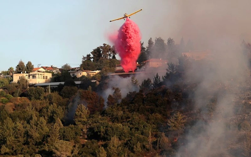 Máy bay rải chất dập lửa gần làng Beit Meir, ngoại ô Jerusalem, ngày 16/8. (Ảnh: Reuters)