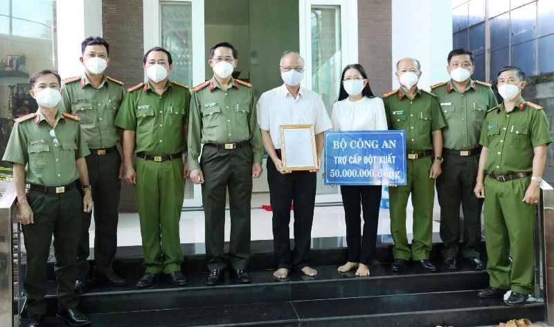 Ðại tá Nguyễn Văn Trãi, Giám đốc Công an tỉnh Tây Ninh (thứ 4, trái sang) trao quyết định của Bộ trưởng Công an, ký thăng cấp từ Đại úy lên Thiếu tá cho gia đình đồng chí Lê Huỳnh Nhật Minh. (Ảnh: Công an Tây Ninh).