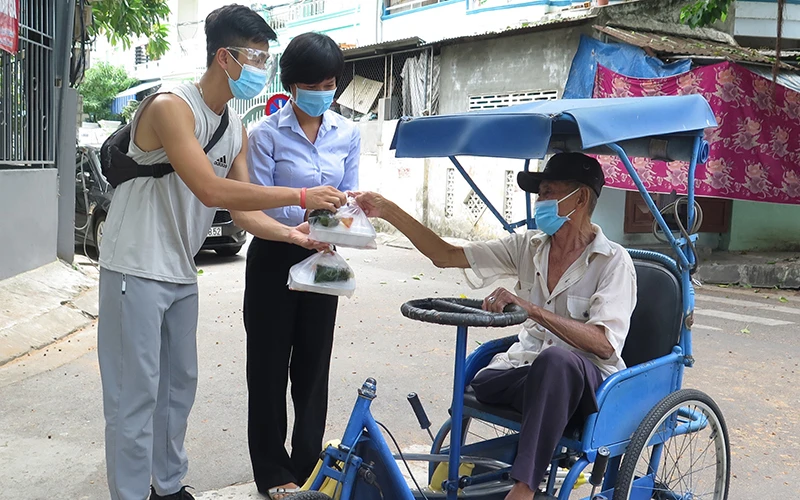 Hành động đẹp giúp đỡ người khó khăn trên đường Huỳnh Thúc Kháng, TP Nha Trang (tỉnh Khánh Hòa). Ảnh TTXVN