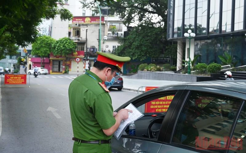 Lực lượng chức năng quận Ba Đình kiểm tra giấy đi đường của người dân tại chốt kiểm soát phòng chống dịch Covid trên đường Thanh Niên. (Ảnh: DUY LINH) 