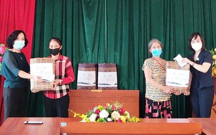 Đại diện Hội LHPN thành phố Hà Nội trao quà tặng nữ lao động di cư trên địa bàn phường Phúc Tân, quận Hoàn Kiếm. Ảnh: THANH HỒNG