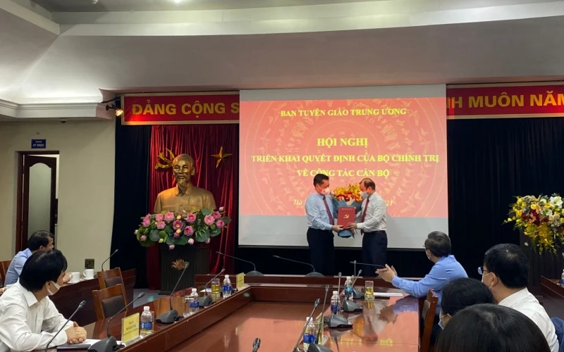 Đồng chí Nguyễn Trọng Nghĩa trao quyết định và tặng hoa, chúc mừng đồng chí Lê Hải Bình.