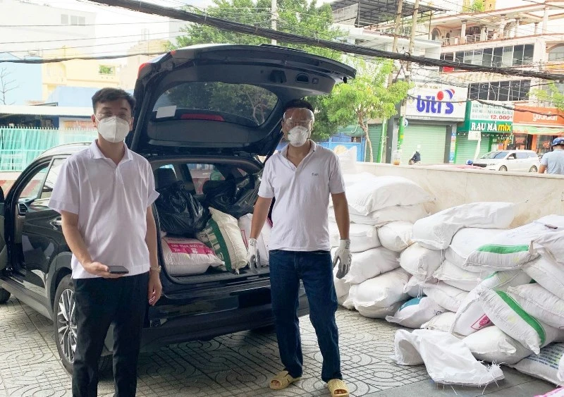 Anh Lê Hùng Anh (bên trái) cùng các cộng sự của công ty chuẩn bị đi trao các nhu yếu phẩm cho người dân có hoàn cảnh khó khăn.