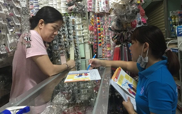 Nhân viên Bưu điện TP Hồ Chí Minh vận động người dân tham gia bảo hiểm xã hội tự nguyện.