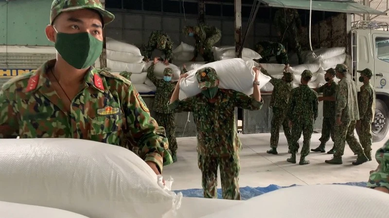 Các chiến sĩ Quân khu 7 hỗ trợ tỉnh Bình Dương đang xuống gạo tại TP Thuận An.