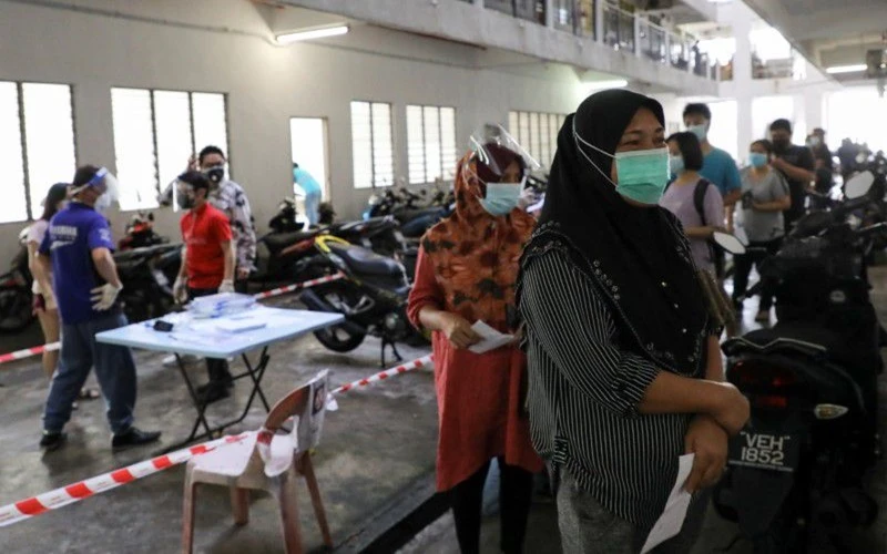 Người dân xếp hàng chờ đến lượt làm xét nghiệm Covid-19 tại Seri Kembangan, Malaysia, tháng 7/2021. (Ảnh: Reuters)