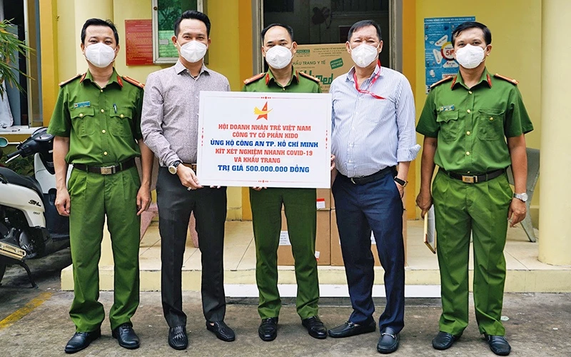 Chủ tịch Hội Doanh nhân trẻ Việt Nam Đặng Hồng Anh (thứ 2 từ trái sang) trao kít xét nghiệm và khẩu trang tặng các cán bộ, chiến sĩ công an TP Hồ Chí Minh.