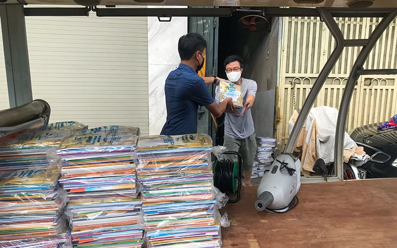 Lực lượng chức năng phường Chương Dương (quận Hoàn Kiếm, TP Hà Nội) chuyển sách giáo khoa đến tận nhà cho học sinh tại khu vực bị phong tỏa. Ảnh: MINH HÀ 