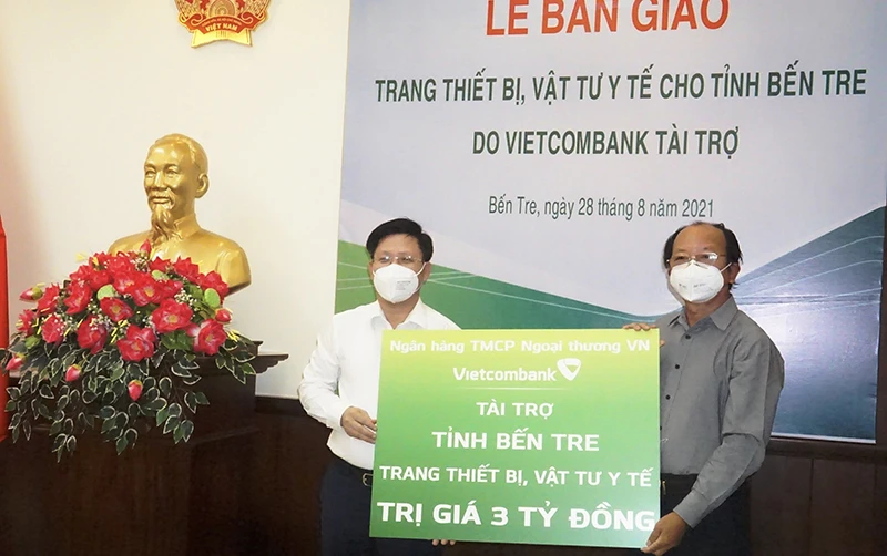 Giám đốc Sở Y tế tỉnh Bến Tre Ngô Văn Tán (phải) trao Bằng khen và Thư cảm ơn cho đơn vị tài trợ.