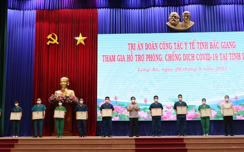 Chủ tịch UBND tỉnh Long An Nguyễn Văn Út trao bằng khen cho các cá nhân đã có thành tích đóng góp cho công tác phòng, chống dịch Covid-19 tại Long An.