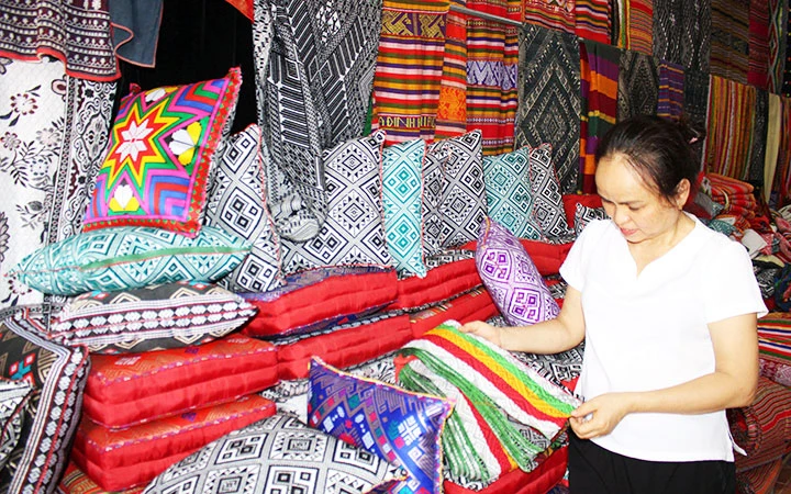 Chị Hà Thị Dung với sản phẩm thổ cẩm truyền thống tại cơ sở sản xuất của gia đình.