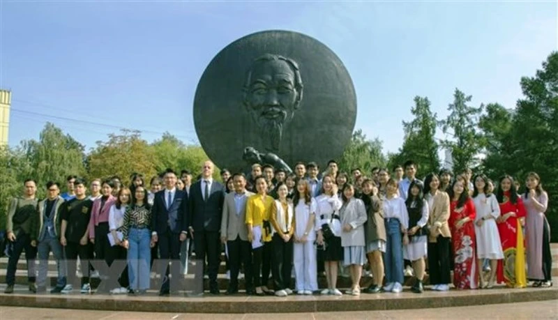 Sinh viên và khách mời chụp ảnh kỷ niệm bên tượng đài Hồ Chí Minh. (Ảnh: TTXVN)