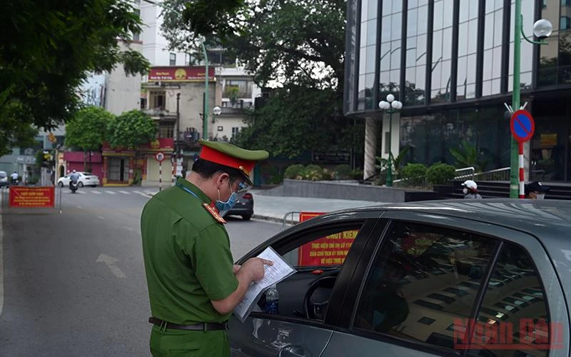 Lực lượng chức năng kiểm tra giấy đi đường của người dân tại lưu thông trên tuyến đường Thanh Niên (Hà Nội). Ảnh: Minh Hà
