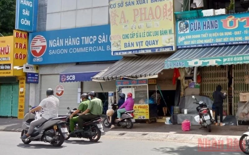 Lực lượng chức năng đi qua các cửa hàng đang kinh doanh nhưng không nhắc nhở. (Ảnh chụp trên đường Nơ Trang Long, quận Bình Thạnh)