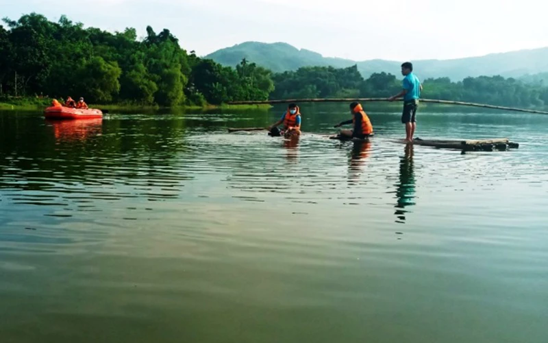 Lực lượng chức năng tìm, vớt nạn nhân đuối nước trong hồ ở xã Đồng Thịnh, huyện Ngọc Lặc.