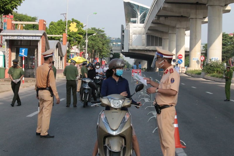 Lực lượng liên ngành kiểm tra việc đi lại của người dân tại điểm chốt kiểm soát dịch trên đường Cầu Diễn.